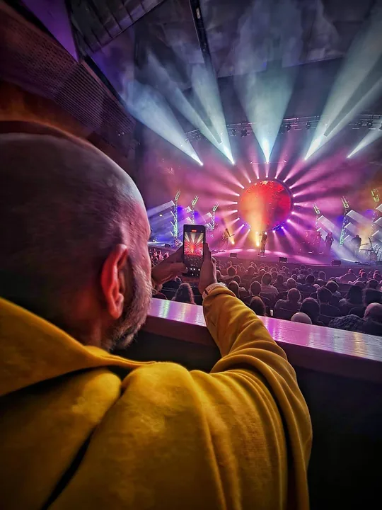 A fan filming the show from the balcony